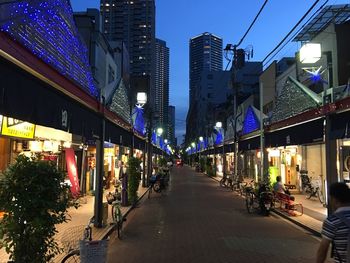 Illuminated street amidst buildings in city at night