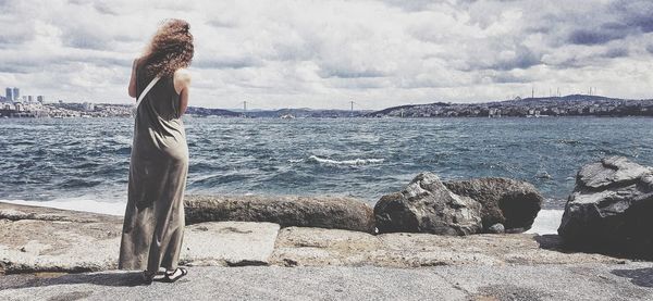 Woman looking at sea against sky