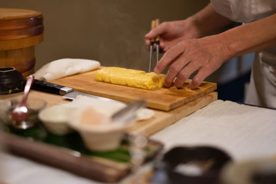 Midsection of person preparing food on cutting board