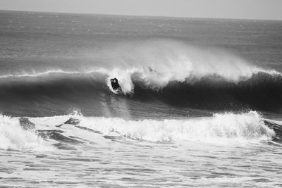 Man surfing on wave at sea