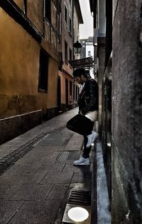 Man walking on road amidst buildings