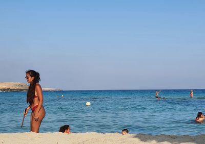 People on beach against sky