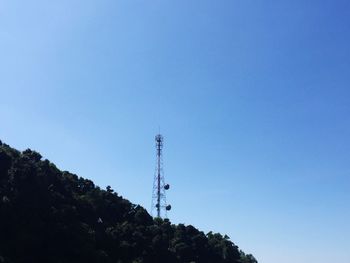 Low angle view of communications tower against blue sky