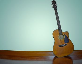 Guitar on table against wall