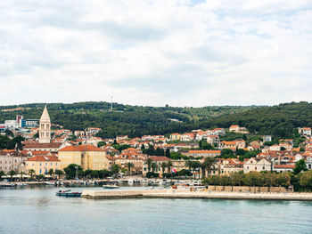 Buildings by river against sky