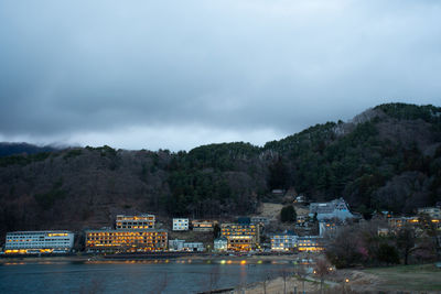 Scenic view of buildings by mountains against sky