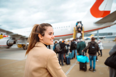 Happy woman walking towards airplane