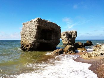 View of rock formation on beach against sky