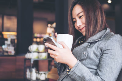 Young woman using smart phone outdoors