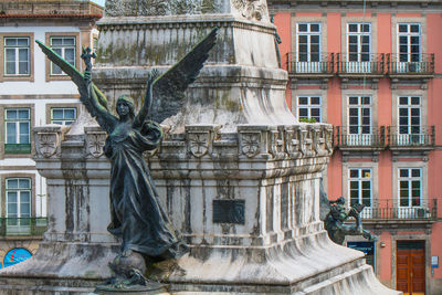 Statue against old building in city