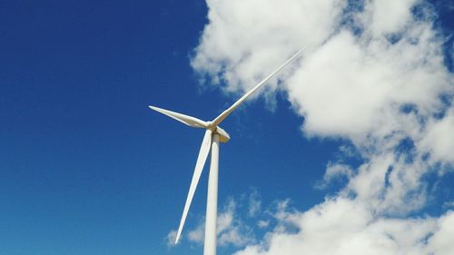 Low angle view of windmill against blue sky