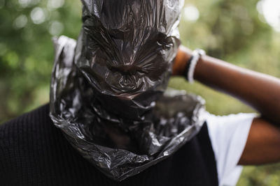 Young african man with plastic over head. plastic pollution concept