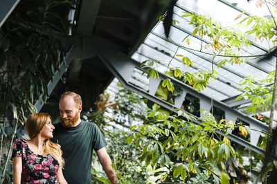 Man and woman standing by plants