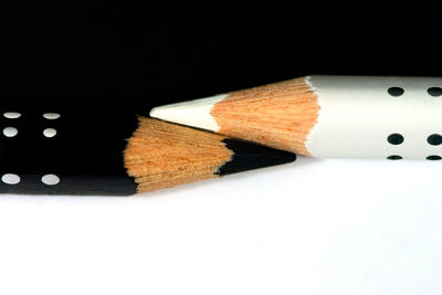 Close-up of colored pencils on table against black background