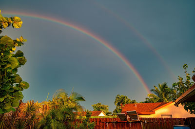Low angle view of rainbow over buildings against sky