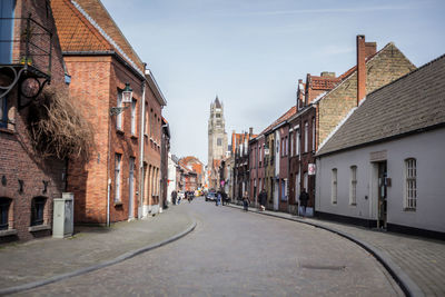 Empty road with buildings in background