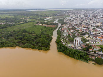 River flooding due to rain causes large mud next to a dam that prevents the rivers from meeting 