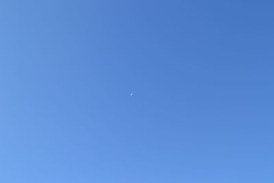 Low angle view of moon in blue sky