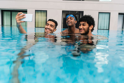 Teenagers making a selfie inside a pool surrounded