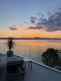 Scenic view of swimming pool by sea against sky during sunset