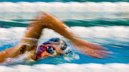 Close-up of young woman swimming in pool