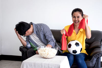 Friends watching sports on tv while sitting at home