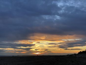 Scenic view of sea against dramatic sky during sunset