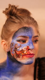  portrait of a young woman. face painting. christmas won't be complete without santa's reindeer.
