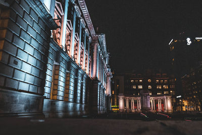 Low angle view of illuminated buildings against sky at night