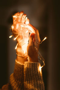 Close-up of woman hand holding illuminated lighting equipment