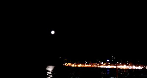 Illuminated city against sky at night