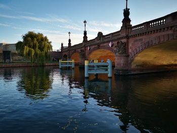 Arch bridge over river against buildings