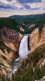 Scenic view of waterfall against sky