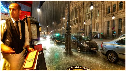 Woman standing on illuminated city street at night