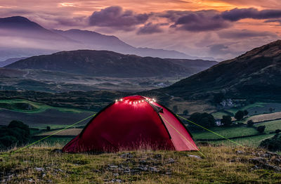 Tent on field by mountains against sky