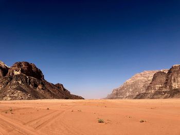 Scenic view of desert against clear blue sky