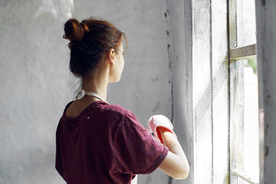 Young woman painting wall