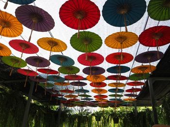 Low angle view of multi colored umbrellas hanging in row