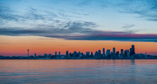 The sun sets creating an eerie glow over the seattle skyline.