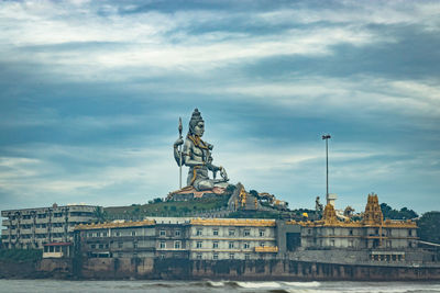 Statue of historic building against cloudy sky