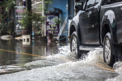 Car running on road with splashing water