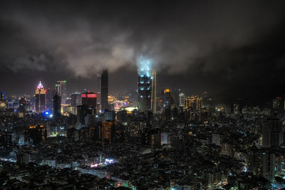 Panoramic view over taipei 101 and surrounding buildings at night during a rain storm. 