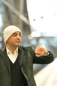 Close-up of mature man checking time at railroad station