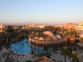High angle view of palm trees and dome building by swimming pool