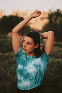 Young woman with arms raised standing on land