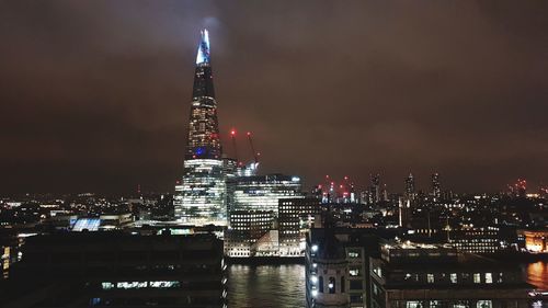 Illuminated buildings against sky at night