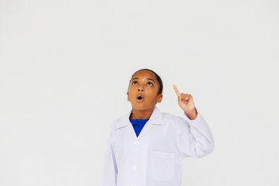 Portrait of young man looking up against white background