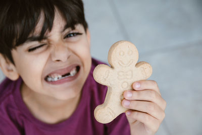 Close-up portrait of boy smiling holding cookie
