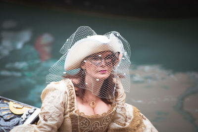 Portrait of woman wearing hat against sea