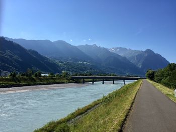 Scenic view of lake by mountains against sky